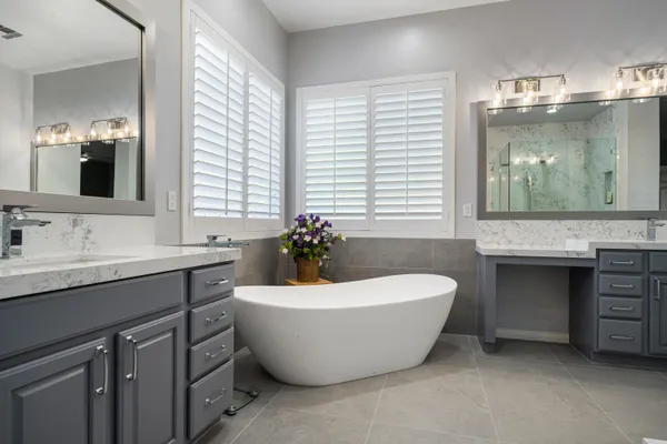 a spacious bathroom with a double vanity sink tub and mirror