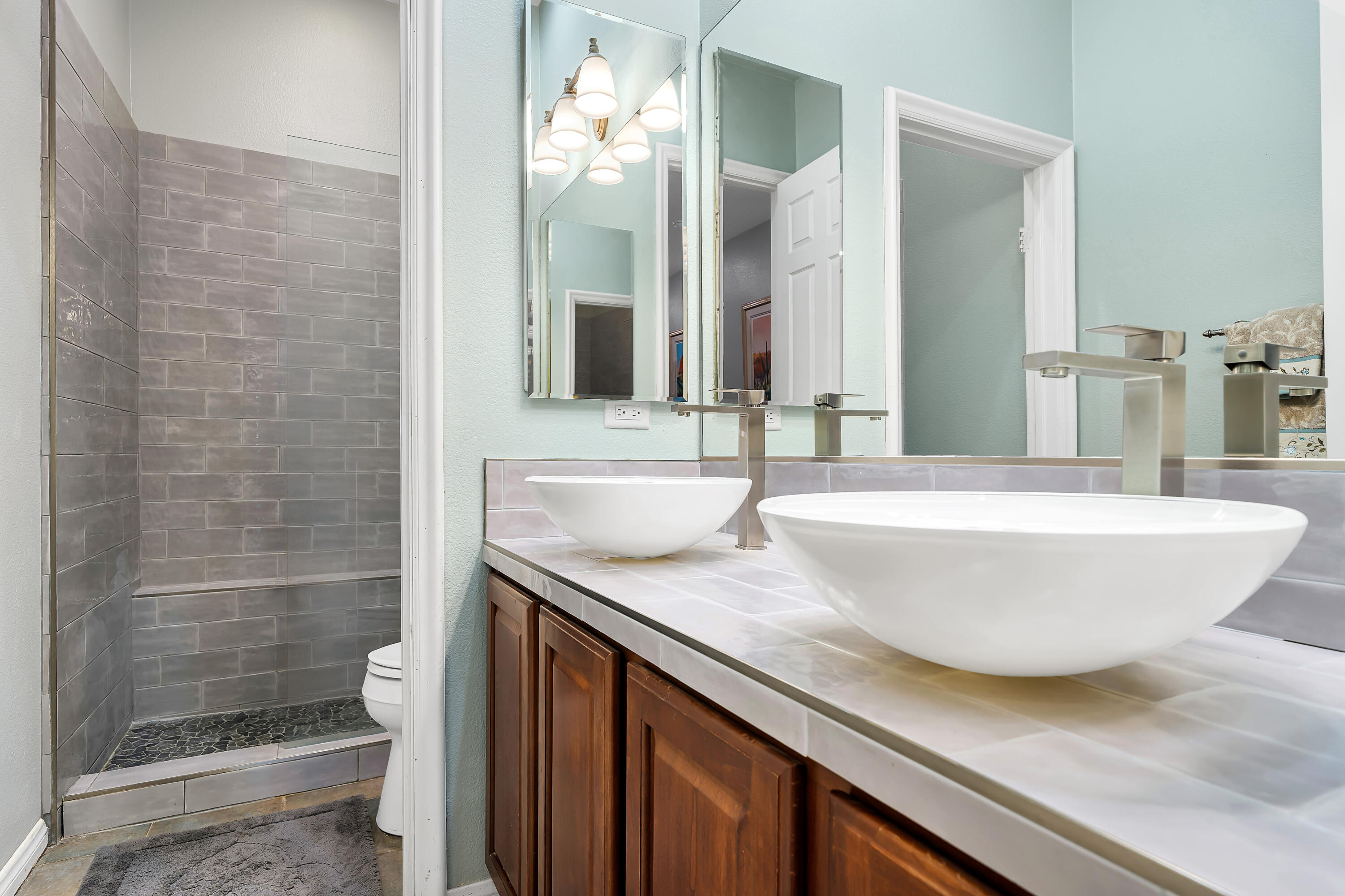 49474 Jordan Street Indio, CA 92201 - Photo 27 of 51 a bathroom with a granite countertop sink a toilet and shower