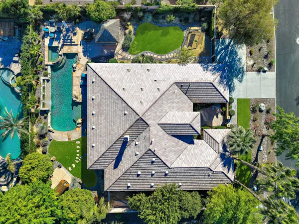 an aerial view of a house with a yard and large trees