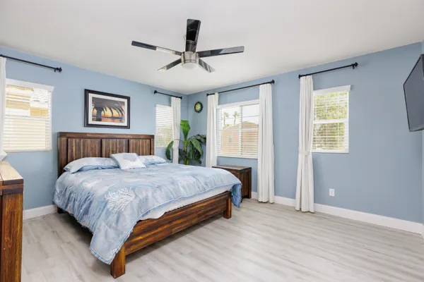 a bed sitting in a spacious bedroom next to a window