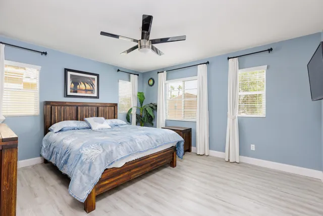a bed sitting in a spacious bedroom next to a window