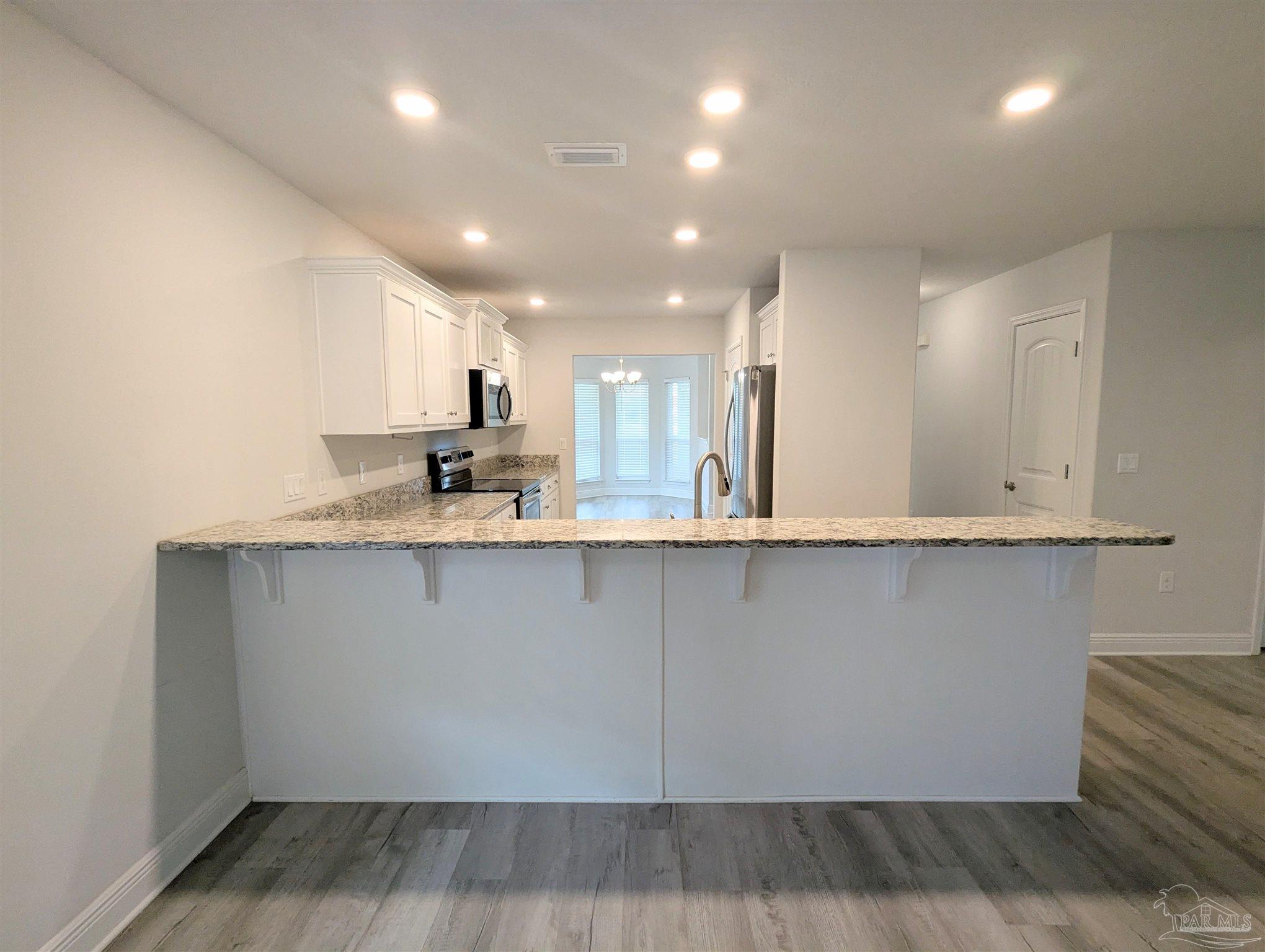 4723 Frances Street Pace, FL 32571 - Photo 15 of 41 a large kitchen with stainless steel appliances a large counter top a stove and a refrigerator