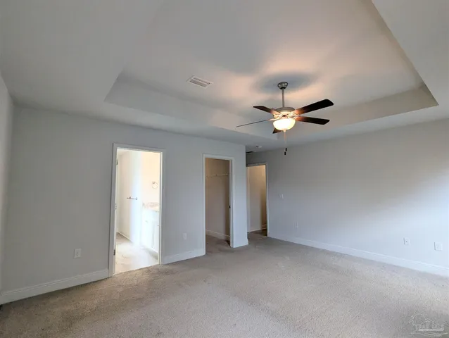 an empty room with closet and a ceiling fan