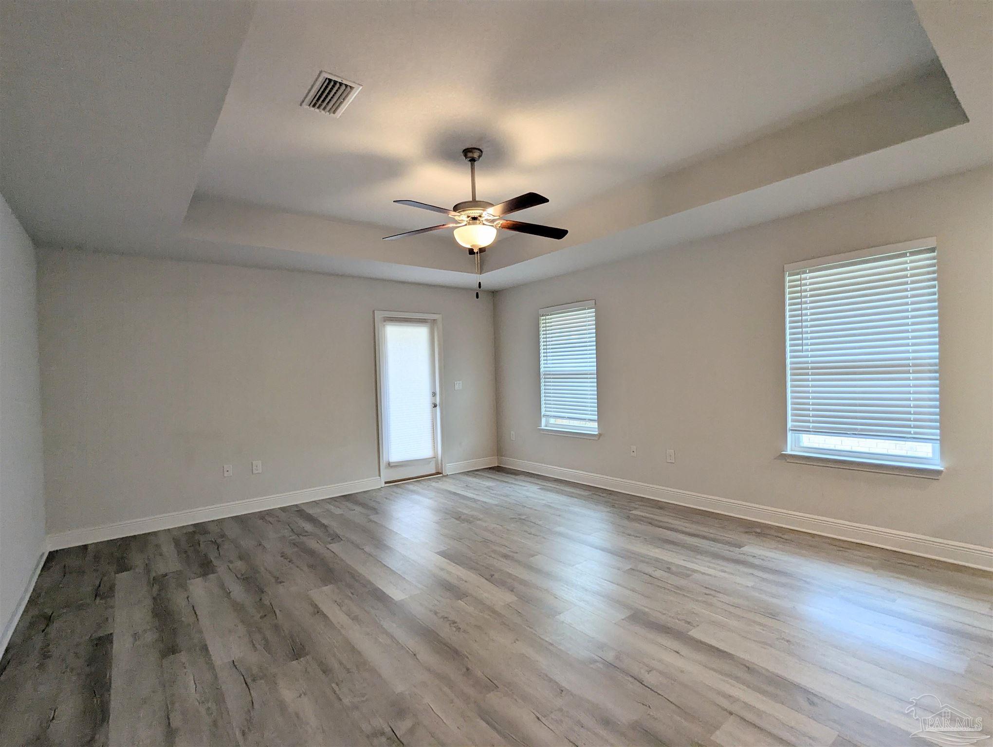 4723 Frances Street Pace, FL 32571 - Photo 25 of 41 an empty room with wooden floor and windows