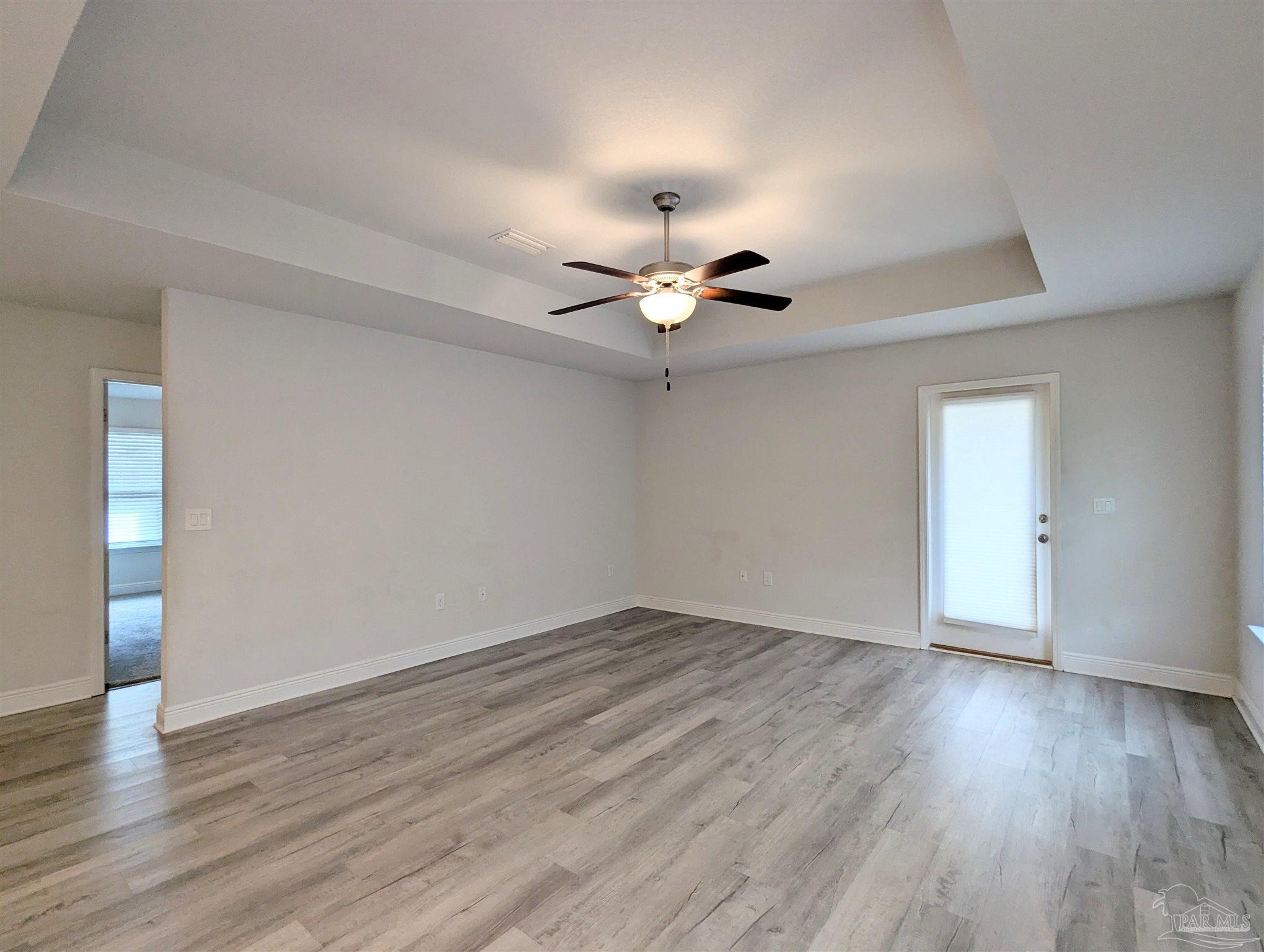4723 Frances Street Pace, FL 32571 - Photo 26 of 41 a view of an empty room with wooden floor