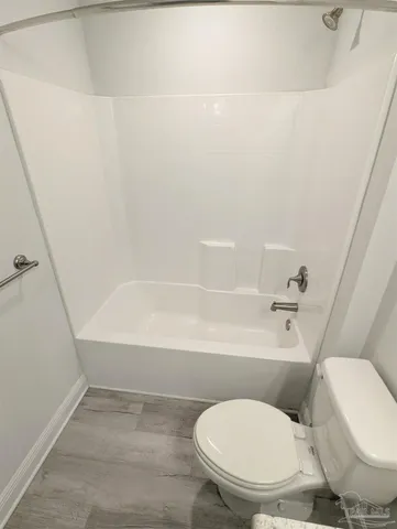 a white toilet sitting next to a bath tub