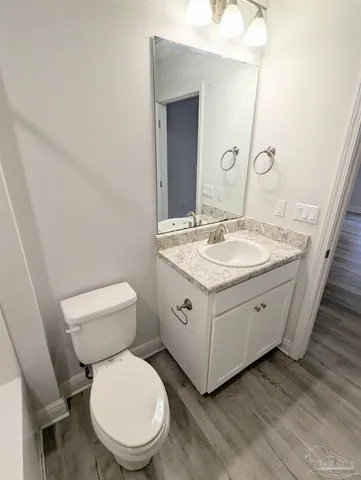 a spacious bathroom with a granite countertop toilet sink and mirror
