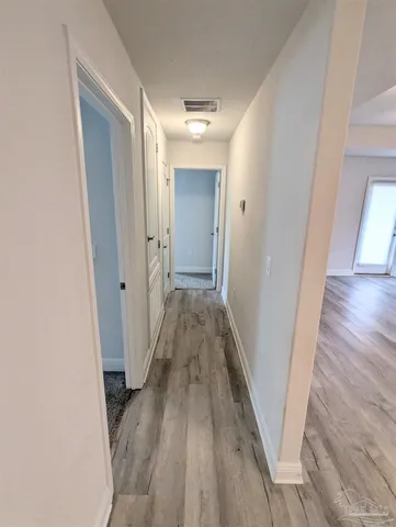 a view of a hallway with wooden floor