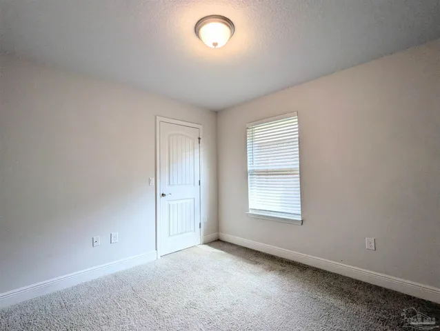 an empty room with a window and mirror