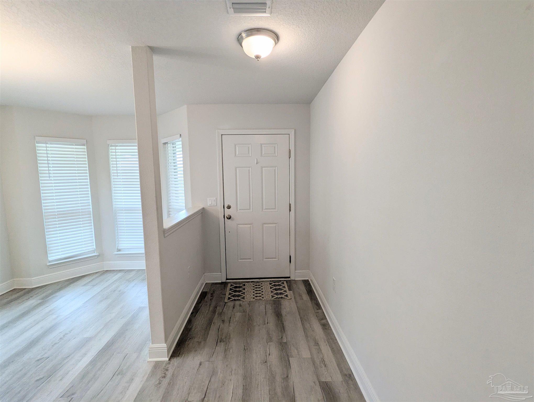 4723 Frances Street Pace, FL 32571 - Photo 4 of 41 a view of a hallway with wooden floor