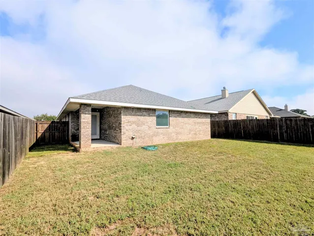 a view of an house with backyard and bushes