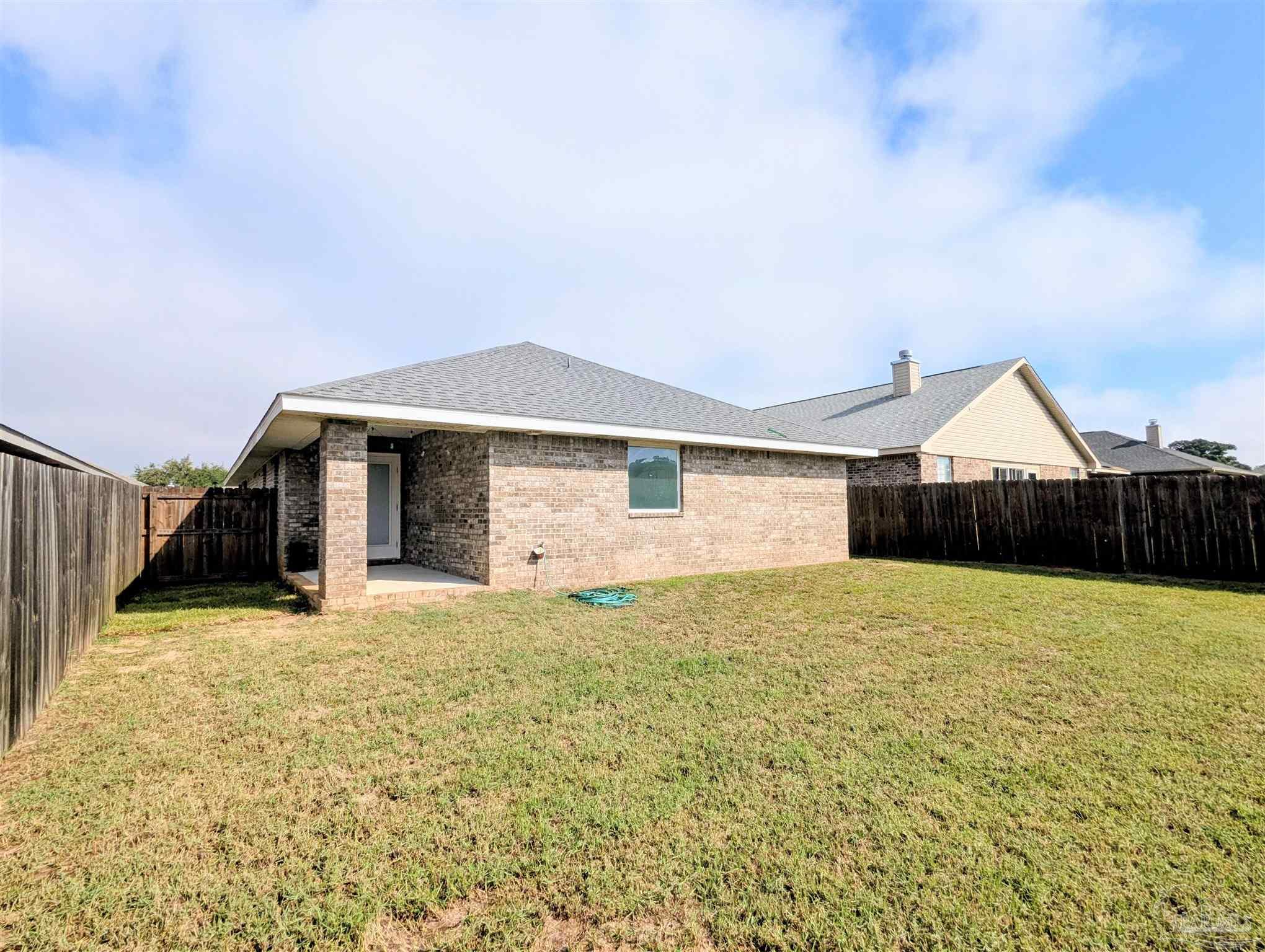 4723 Frances Street Pace, FL 32571 - Photo 41 of 41 a view of an house with backyard and bushes