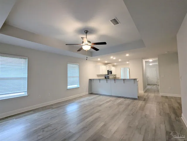 a view of kitchen and hall with wooden floor