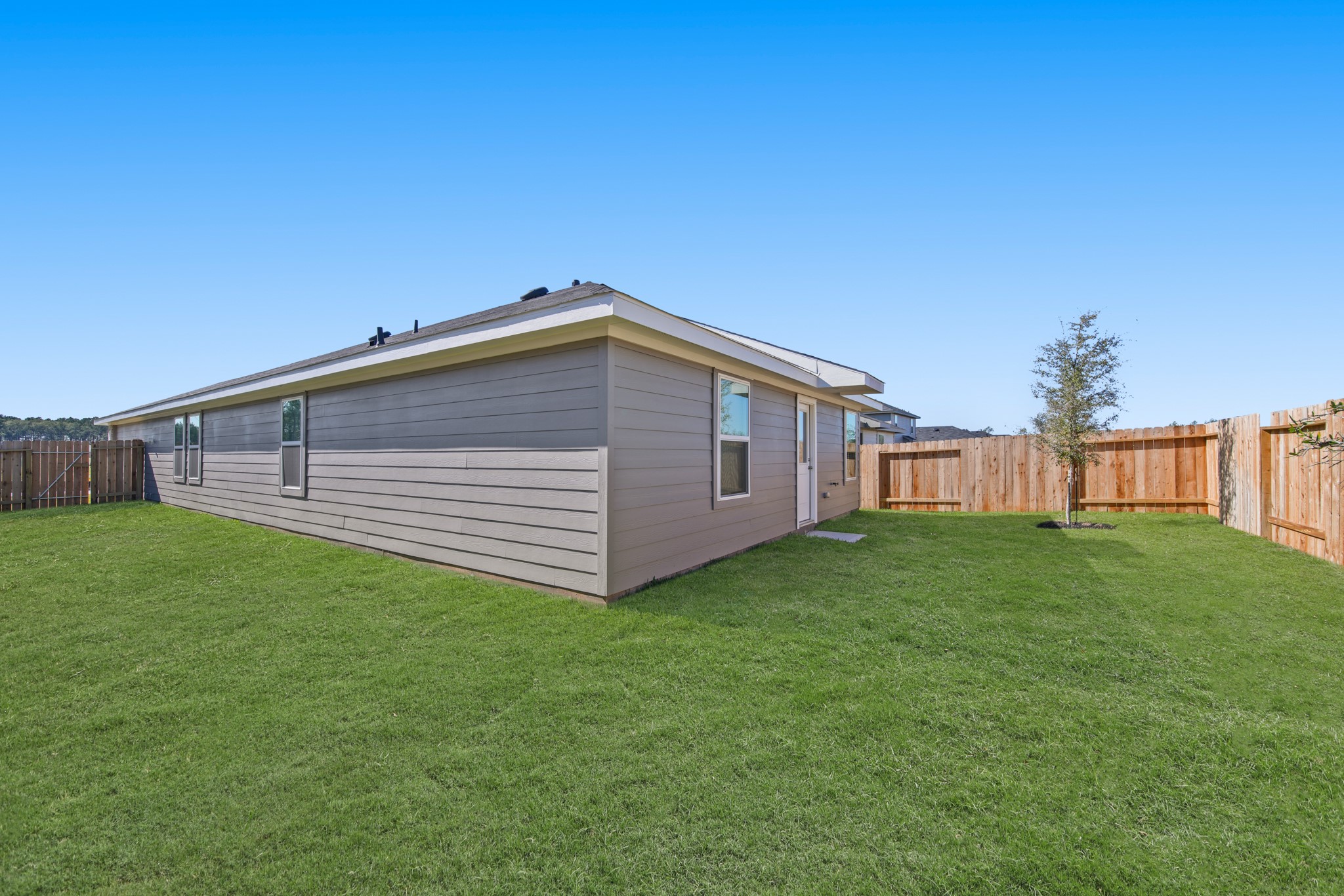 965 Sutherland Falls Street Conroe, TX 77303 - Photo 23 of 35 a view of a backyard with potted plants and large tree