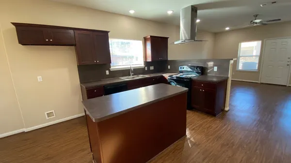 a kitchen with granite countertop a sink a counter space and cabinets