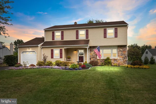 a front view of a house with a garden and yard