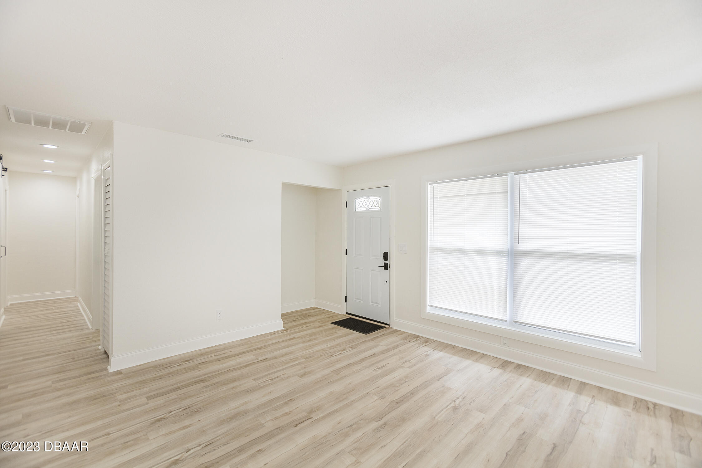 489 Wiltshire Boulevard Port Orange, FL 32127 - Photo 12 of 40 an empty room with wooden floor and windows