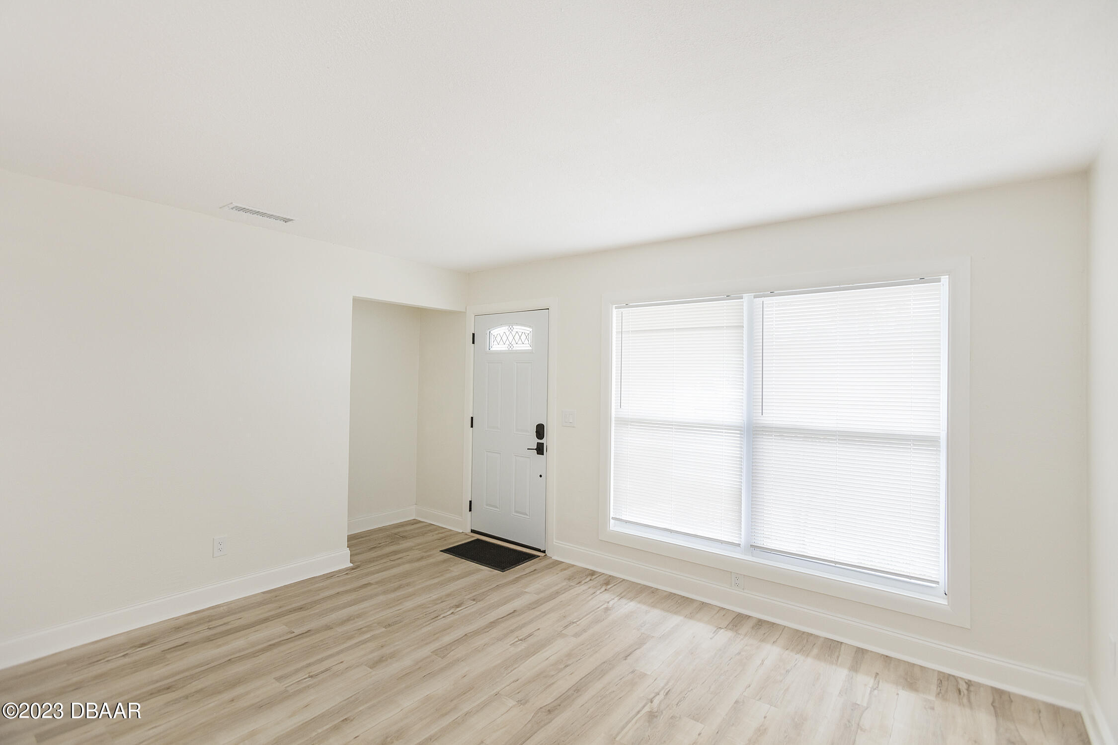 489 Wiltshire Boulevard Port Orange, FL 32127 - Photo 13 of 40 an empty room with wooden floor and windows