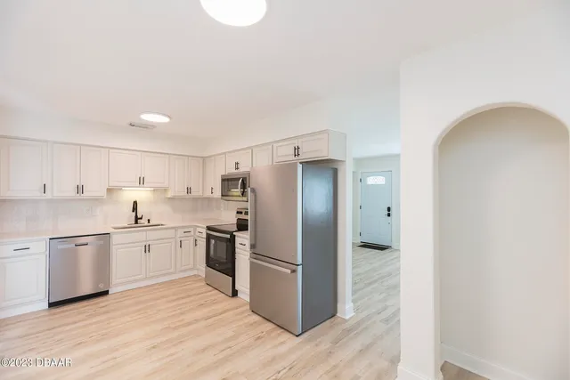 a kitchen with stainless steel appliances granite countertop a refrigerator and a stove top oven