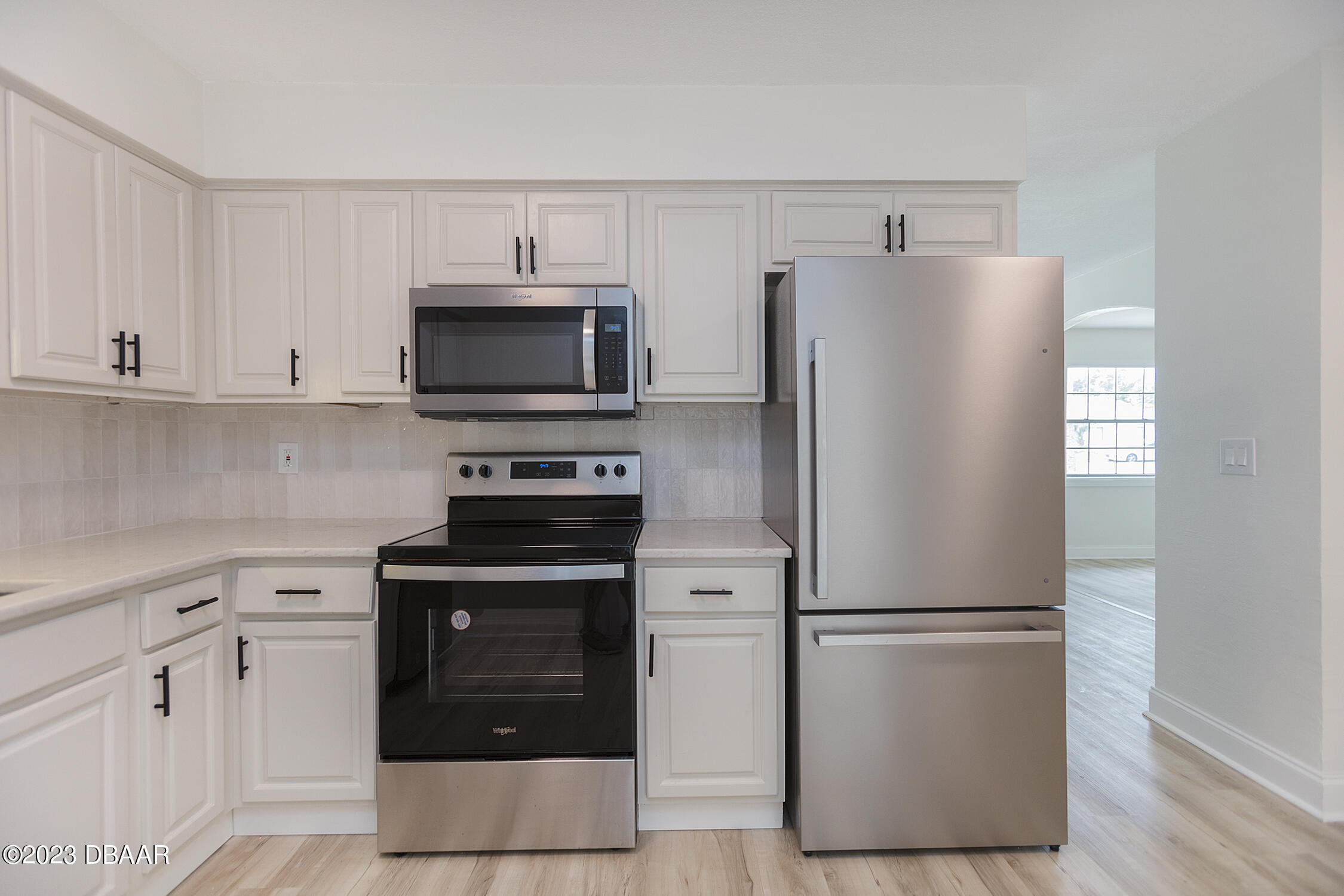 489 Wiltshire Boulevard Port Orange, FL 32127 - Photo 23 of 40 a kitchen with a refrigerator stove and white cabinets