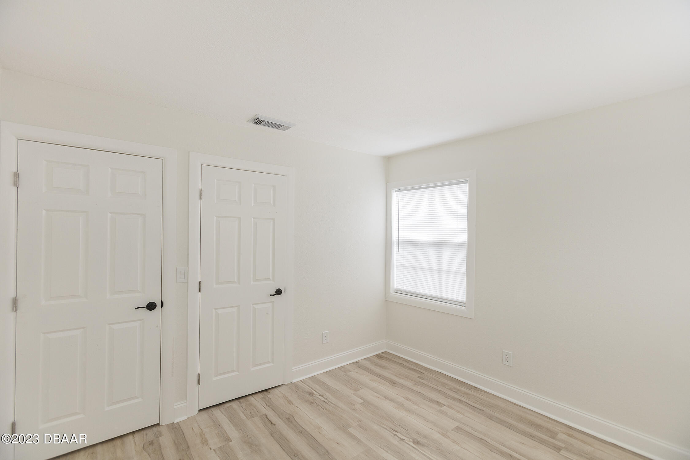 489 Wiltshire Boulevard Port Orange, FL 32127 - Photo 30 of 40 a view of an empty room with wooden floor and a window