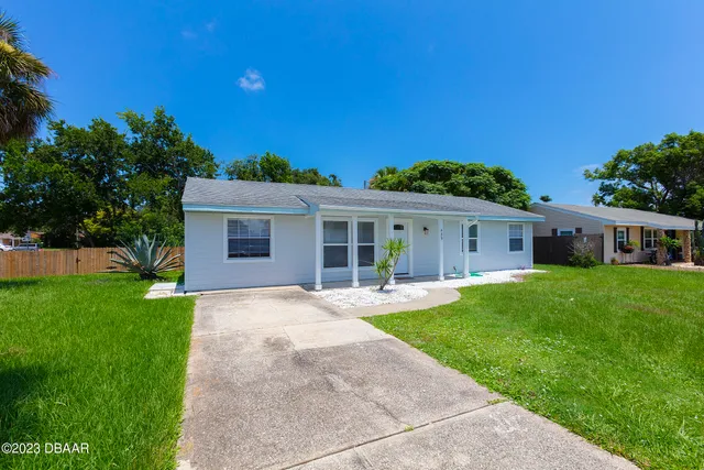 a front view of a house with a garden and yard