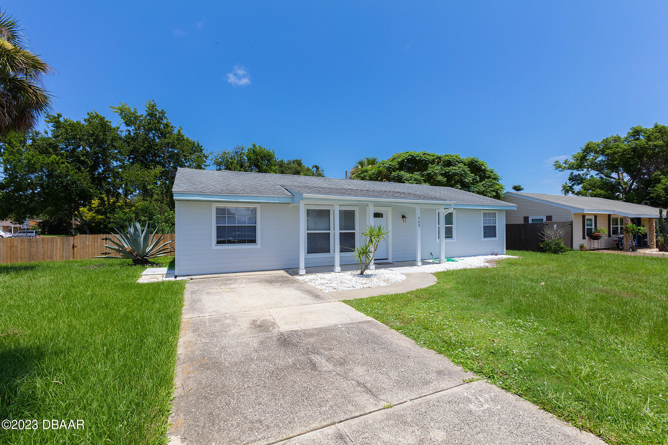 489 Wiltshire Boulevard Port Orange, FL 32127 - Photo 3 of 40 a front view of a house with a garden and yard