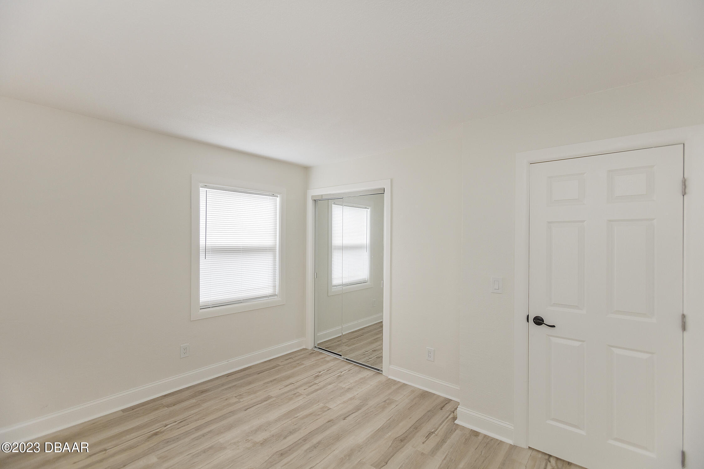 489 Wiltshire Boulevard Port Orange, FL 32127 - Photo 33 of 40 an empty room with wooden floor and windows