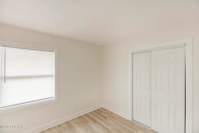 a view of a small space with wooden floor and a window