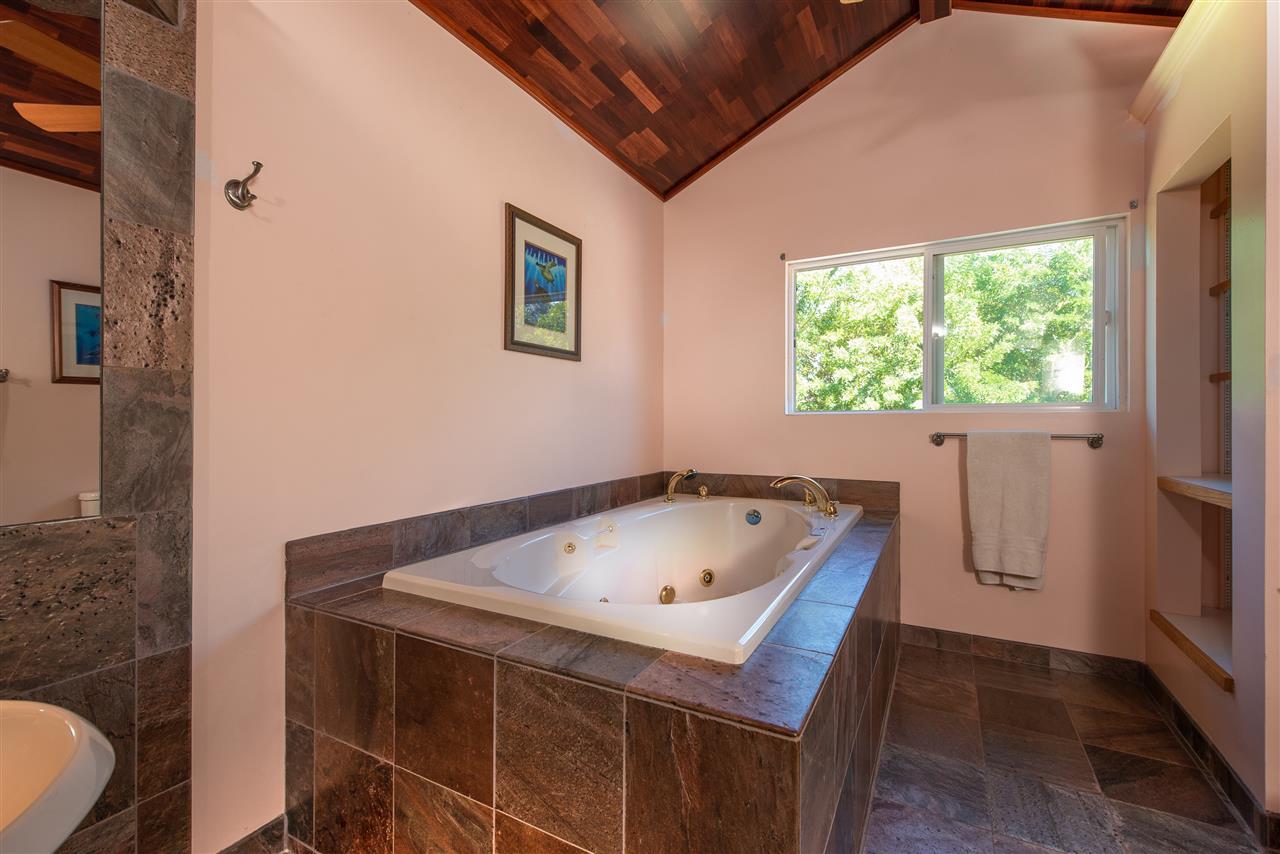 65 Door Of Faith Road Haiku, HI 96708 - Photo 19 of 30 a bathroom with a tub sink and mirror