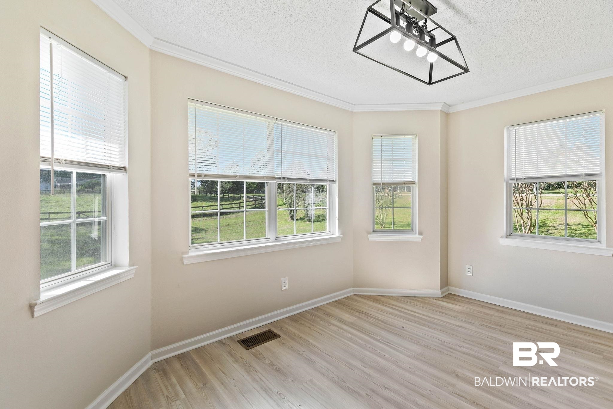 35650 Spring Road North Stapleton, AL 36578 - Photo 19 of 70 Empty room with a textured ceiling, light wood-style floors, and crown molding