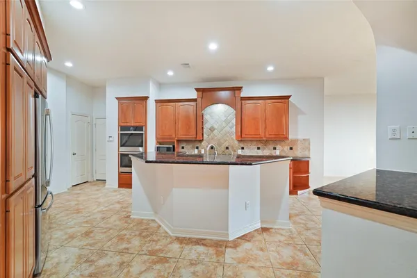 a view of kitchen with stainless steel appliances granite countertop sink and cabinets