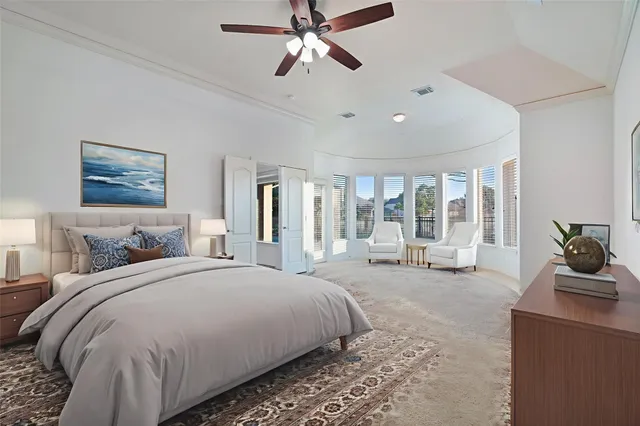 a spacious bedroom with a large bed and a chandelier