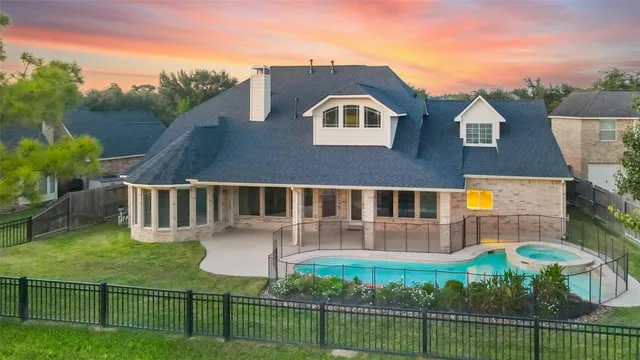 a front view of a house with garden and trees