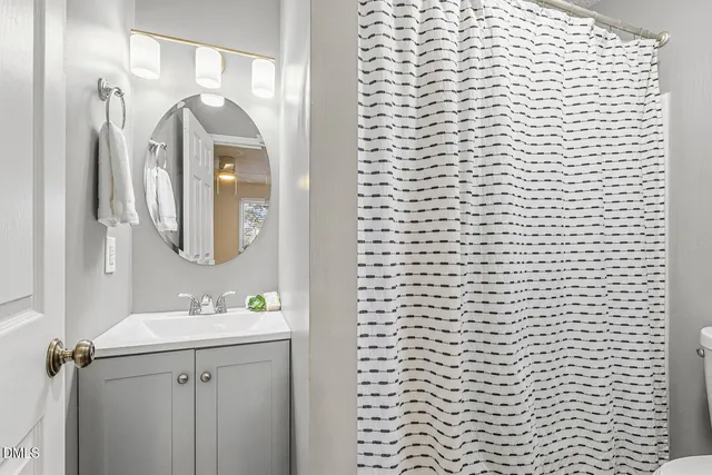 a bathroom with a shower curtain and a sink