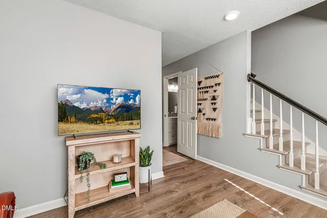 a view of a hallway with wooden floor and dining room