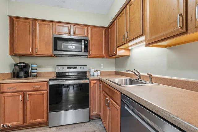 a kitchen with stainless steel appliances granite countertop a sink and a stove