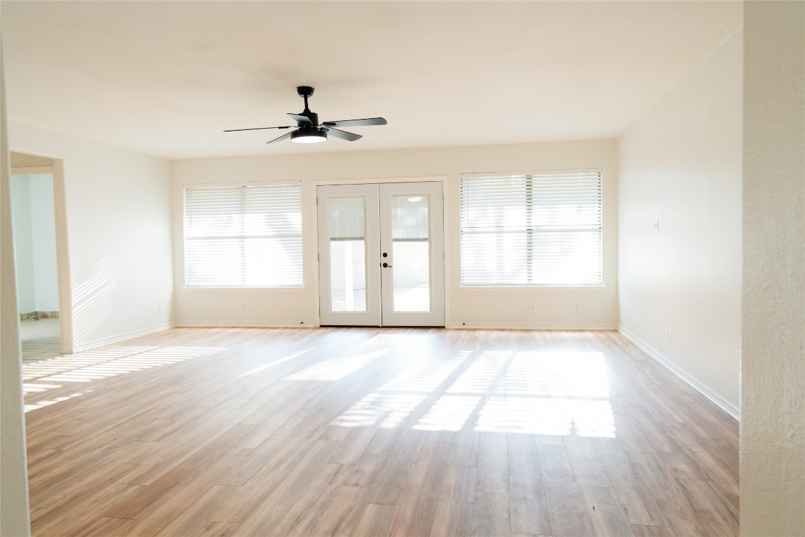 13002 Cedarhurst Circle Austin, TX 78729 - Photo 19 of 40 an empty room with wooden floor ceiling fan and windows