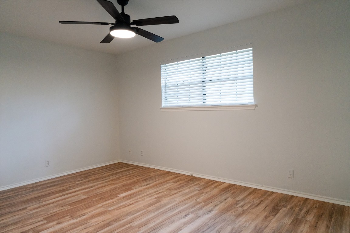 13002 Cedarhurst Circle Austin, TX 78729 - Photo 24 of 40 an empty room with wooden floor ceiling fan and windows