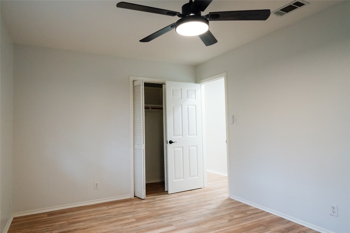 13002 Cedarhurst Circle Austin, TX 78729 - Photo 25 of 40 an empty room with wooden floor chandelier fan and closet area