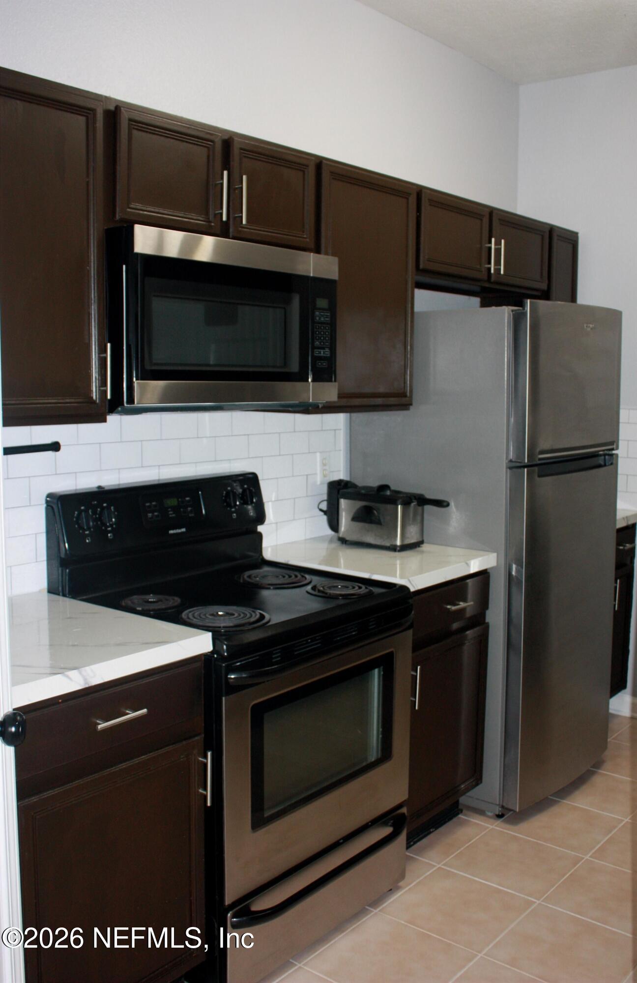 7990 Baymeadows Road East, Unit 530 Jacksonville, FL 32256 - Photo 6 of 21 a kitchen with a stove microwave and refrigerator