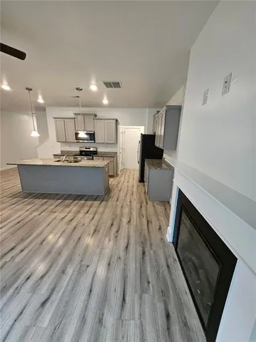 a large kitchen with a wooden floor and stainless steel appliances