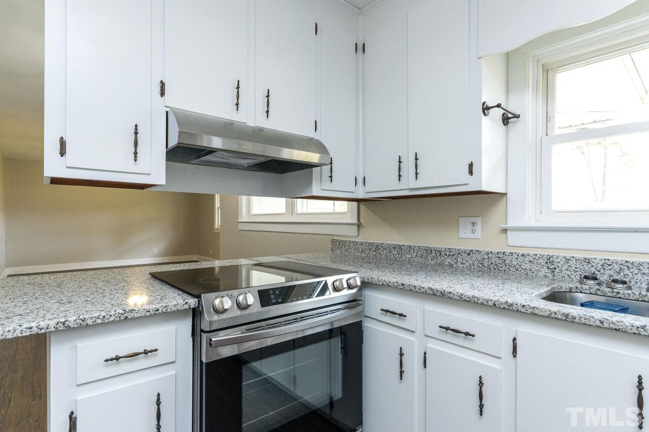 1309 Legend Road Raleigh, NC 27603 - Photo 12 of 27 a kitchen with stainless steel appliances granite countertop white cabinets and a stove a sink