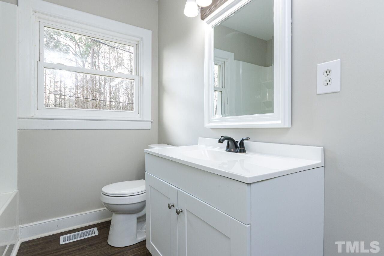1309 Legend Road Raleigh, NC 27603 - Photo 18 of 27 a bathroom with a toilet sink and mirror