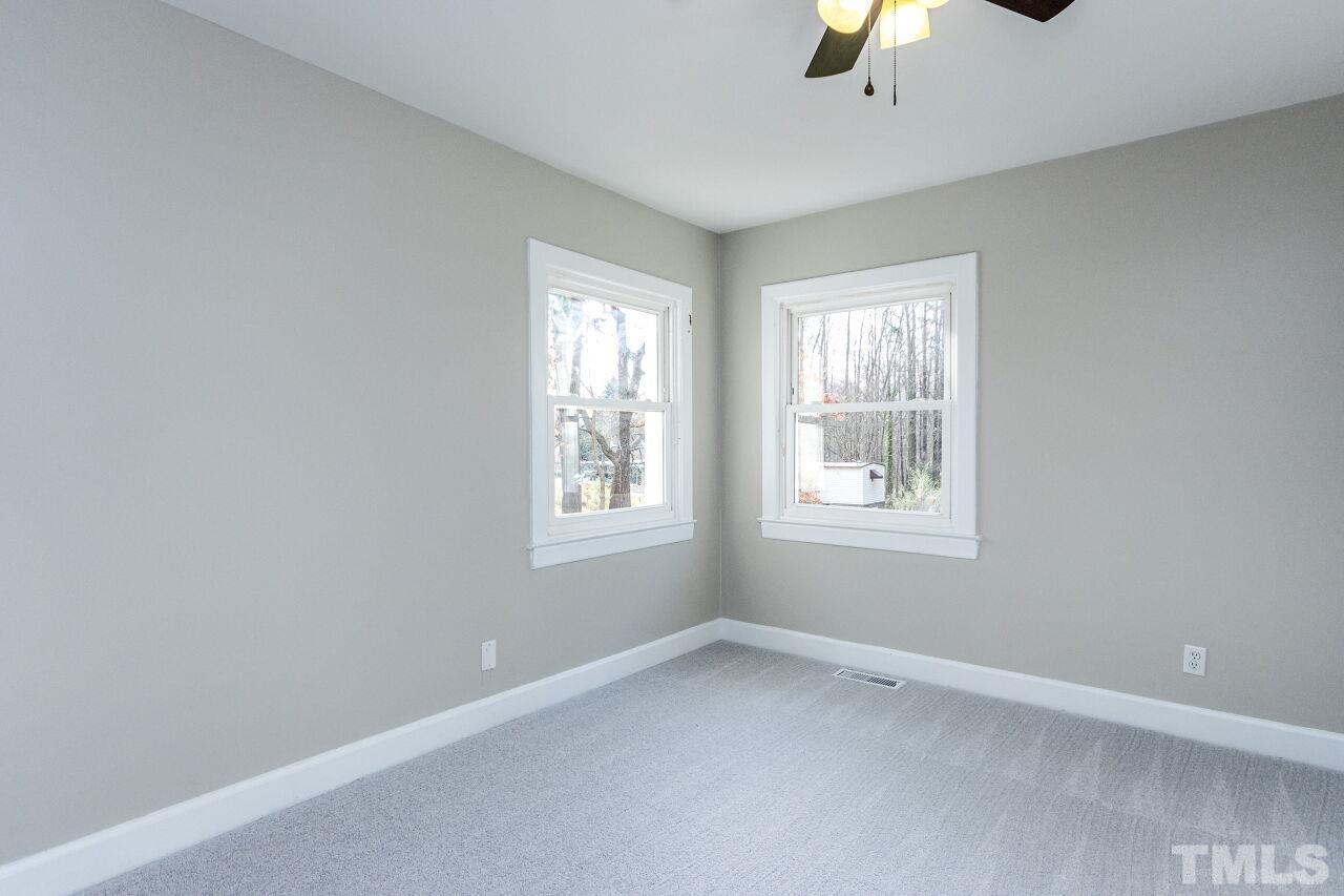 1309 Legend Road Raleigh, NC 27603 - Photo 22 of 27 an empty room with windows and chandelier fan