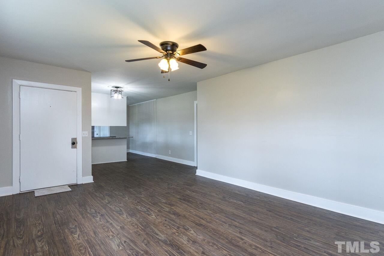 1309 Legend Road Raleigh, NC 27603 - Photo 7 of 27 a view of an empty room with wooden floor and a ceiling fan