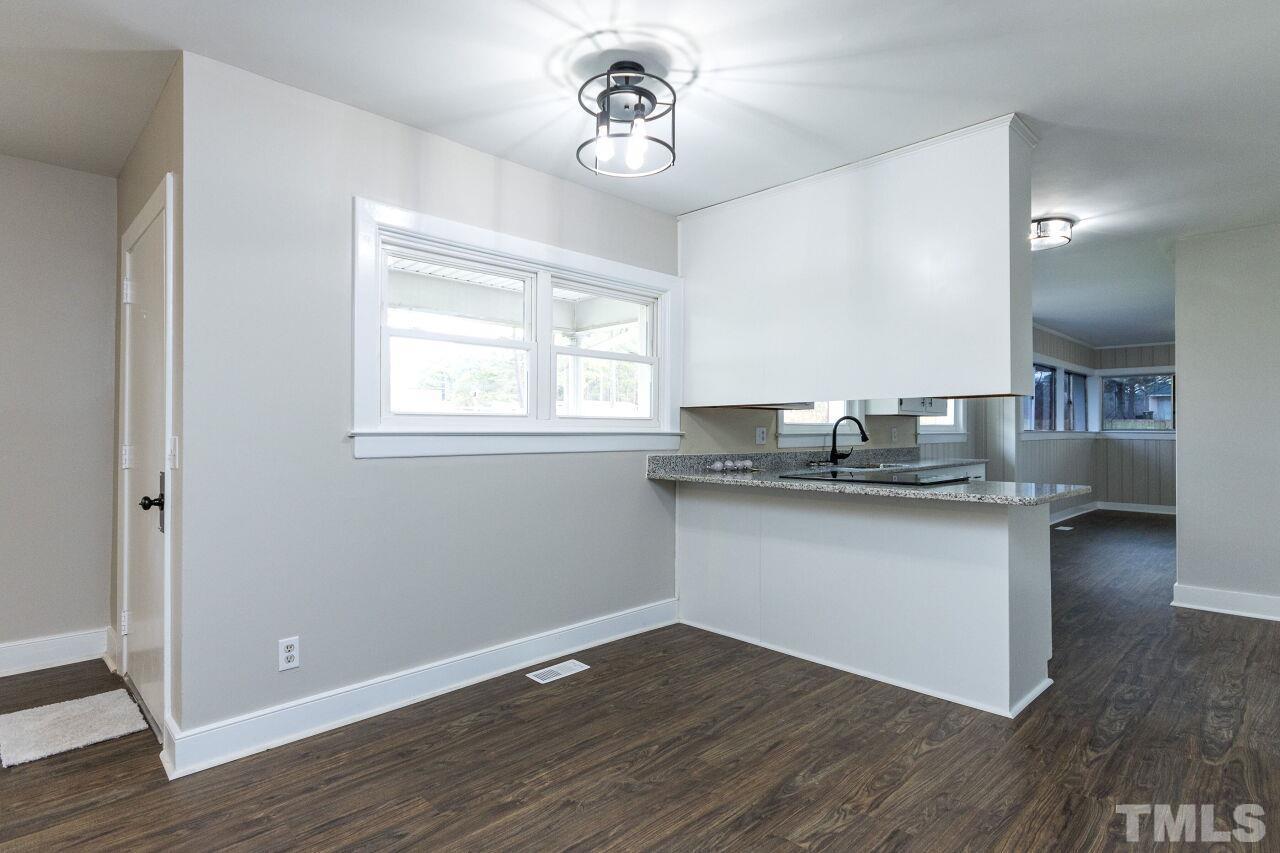 1309 Legend Road Raleigh, NC 27603 - Photo 8 of 27 a kitchen with granite countertop a sink cabinets and wooden floor