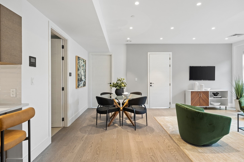 69 Walnut Street, Unit 10A Brookline, MA 02445 - Photo 2 of 17 a living room with furniture and a flat screen tv