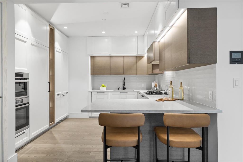 69 Walnut Street, Unit 10A Brookline, MA 02445 - Photo 6 of 17 a kitchen with stainless steel appliances granite countertop a sink and a refrigerator