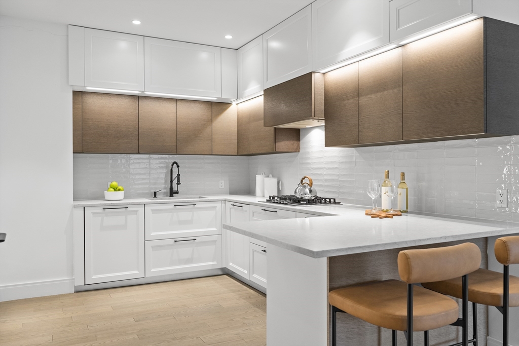 69 Walnut Street, Unit 10A Brookline, MA 02445 - Photo 7 of 17 a kitchen with a sink cabinets and wooden floor